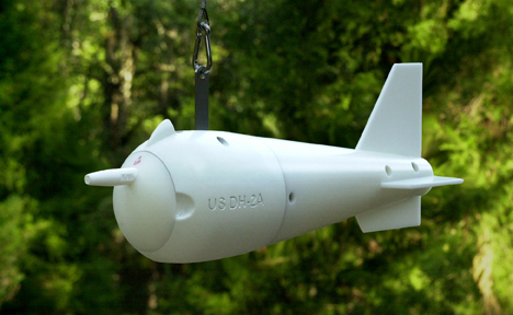 US DH-2A suspended-sediment sampler hanging from a hand line against a forest backdrop